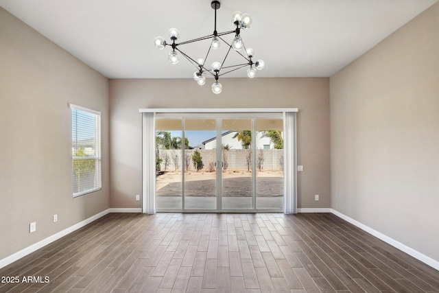 unfurnished room featuring a chandelier