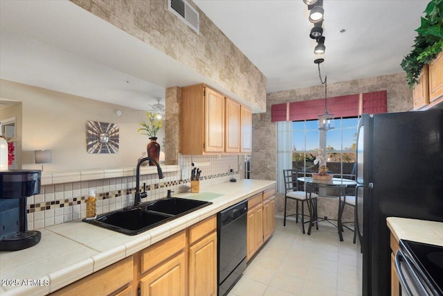 kitchen featuring sink, an inviting chandelier, tile countertops, dishwasher, and tasteful backsplash