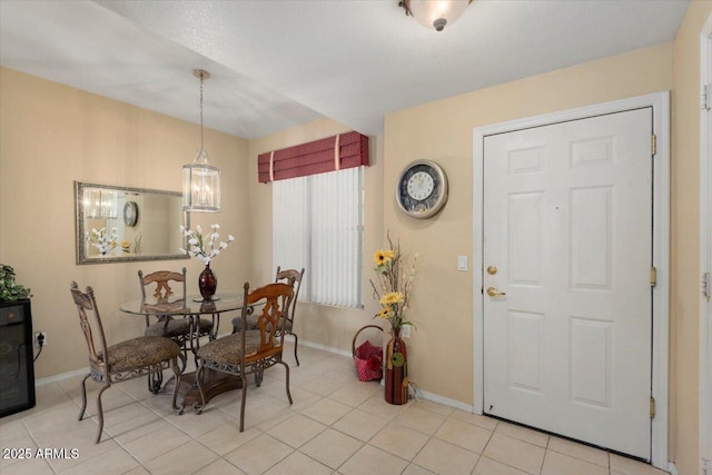 tiled dining room with a chandelier