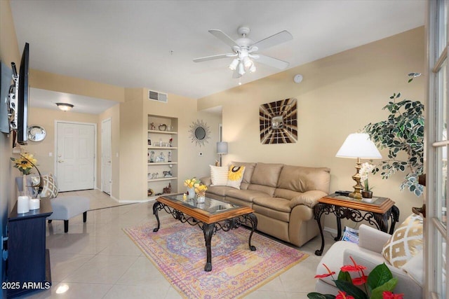 living room featuring ceiling fan, light tile patterned floors, and built in features