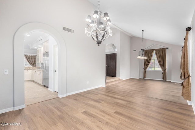 unfurnished dining area with arched walkways, high vaulted ceiling, a chandelier, light wood-style floors, and baseboards