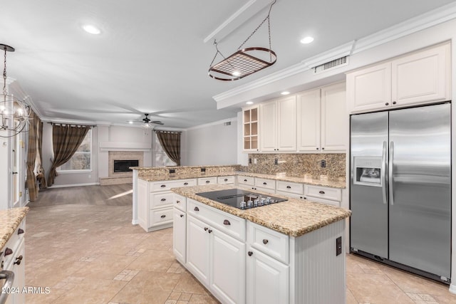 kitchen featuring built in refrigerator, black electric stovetop, ceiling fan, ornamental molding, and a fireplace with raised hearth