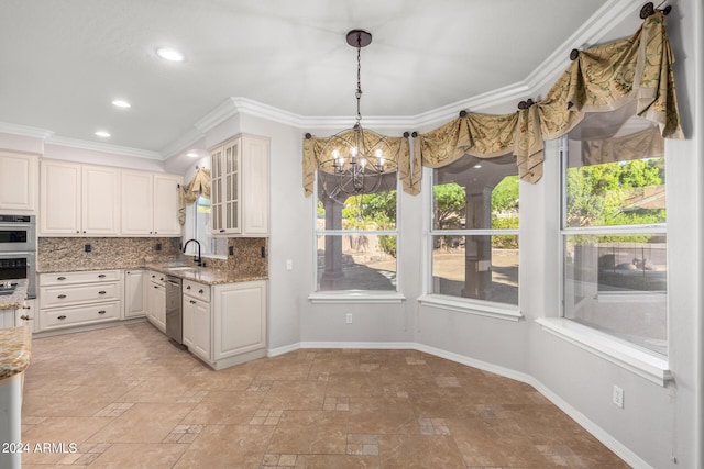 kitchen featuring a chandelier, appliances with stainless steel finishes, light stone countertops, decorative backsplash, and ornamental molding