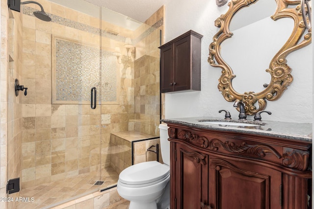 full bathroom featuring toilet, a stall shower, and vanity