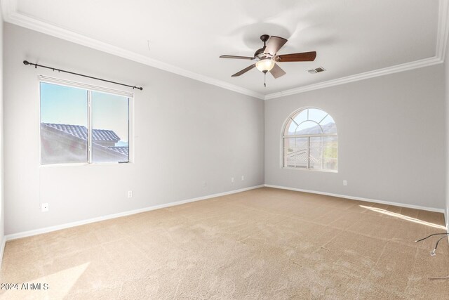spare room featuring crown molding, carpet flooring, healthy amount of natural light, ceiling fan, and baseboards