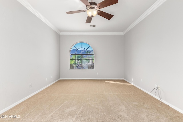 unfurnished room with light colored carpet, ornamental molding, baseboards, and a ceiling fan