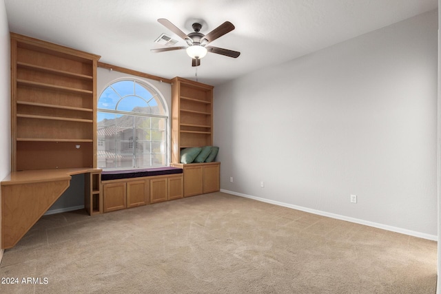 unfurnished office featuring ceiling fan, light colored carpet, and baseboards