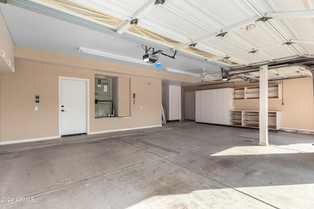 garage featuring a garage door opener, baseboards, and heating unit