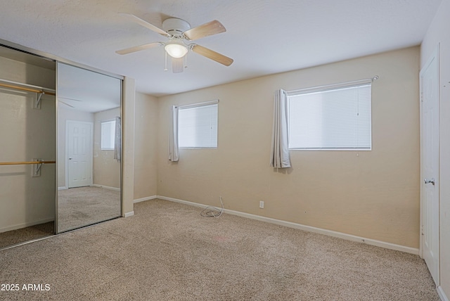 unfurnished bedroom featuring a ceiling fan, carpet, a closet, and baseboards