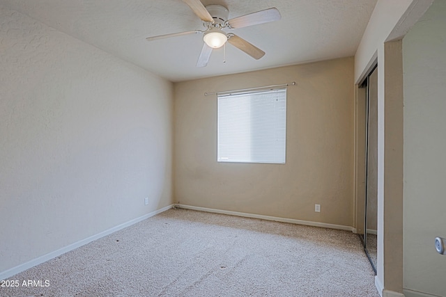 unfurnished bedroom with ceiling fan, carpet floors, a closet, and baseboards