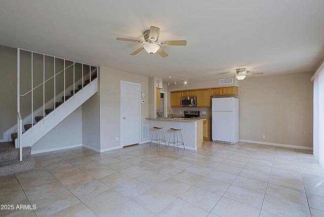 unfurnished living room featuring stairs, ceiling fan, visible vents, and baseboards