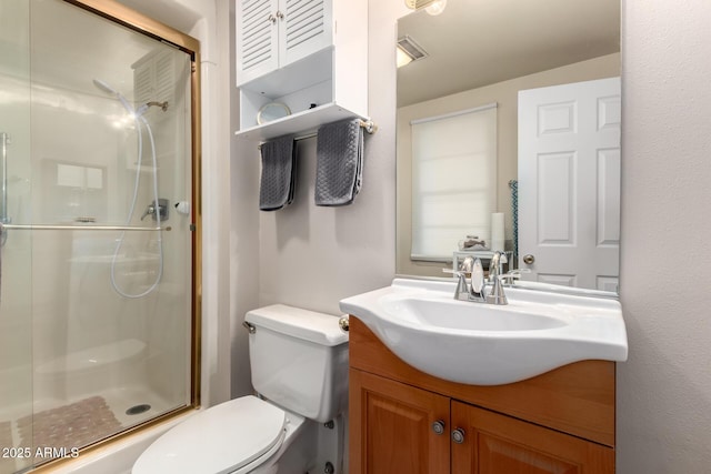 bathroom with a stall shower, vanity, and toilet