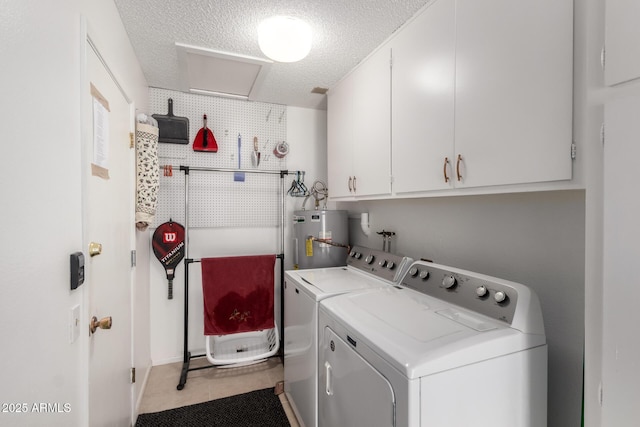 laundry room with washer and clothes dryer, water heater, cabinet space, light tile patterned flooring, and a textured ceiling