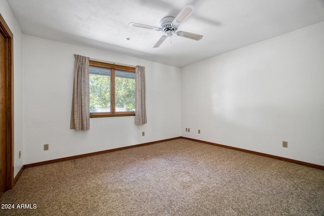 carpeted spare room featuring ceiling fan