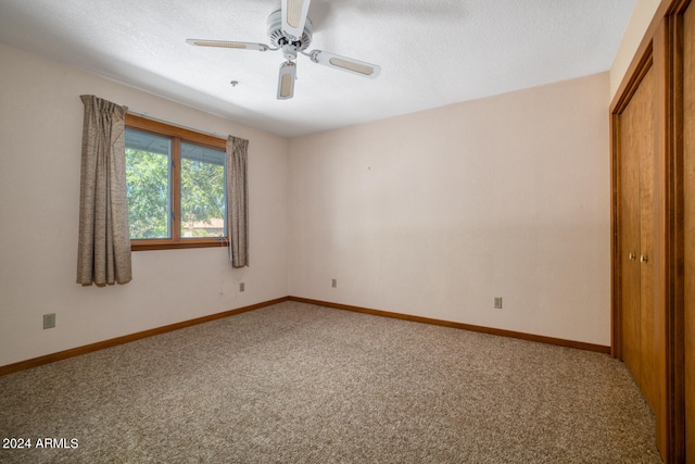 unfurnished bedroom with carpet, ceiling fan, a textured ceiling, and a closet