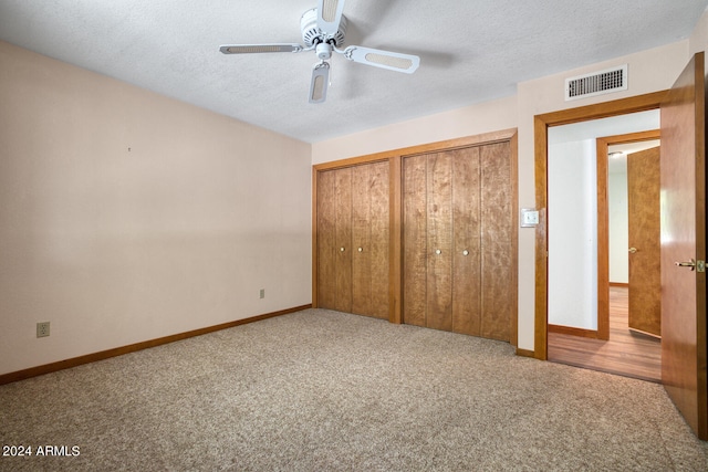 unfurnished bedroom with ceiling fan, carpet floors, and a textured ceiling