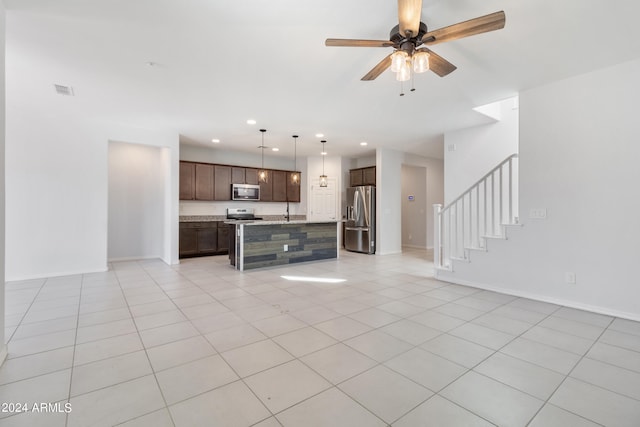 kitchen featuring appliances with stainless steel finishes, ceiling fan, a center island with sink, and light tile patterned floors