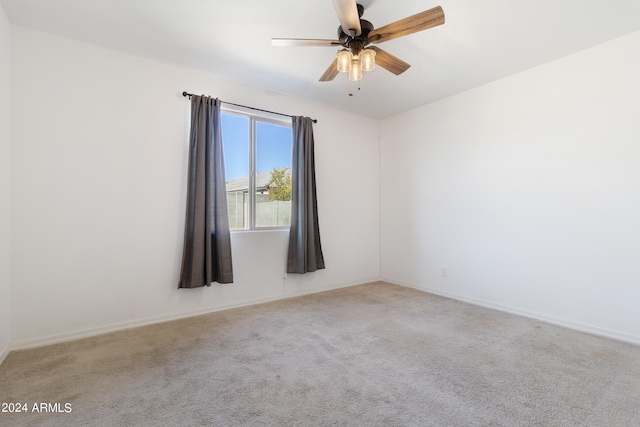 carpeted spare room featuring ceiling fan