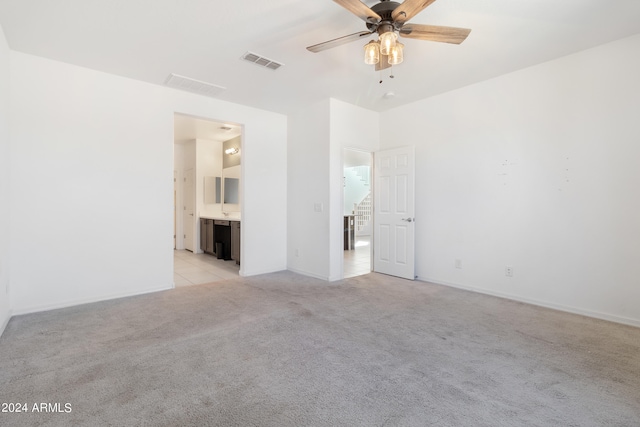 unfurnished room with light colored carpet and ceiling fan