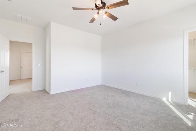 empty room with ceiling fan and light colored carpet