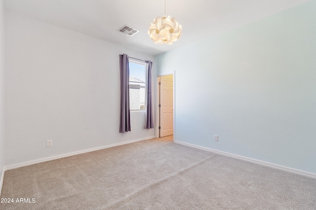 spare room featuring light carpet