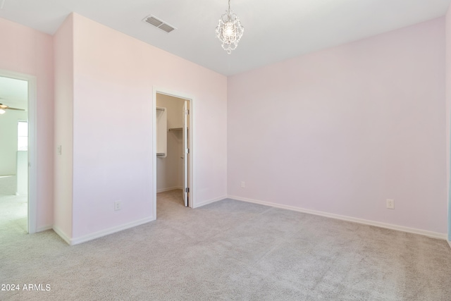 unfurnished bedroom with light carpet, a closet, and a spacious closet