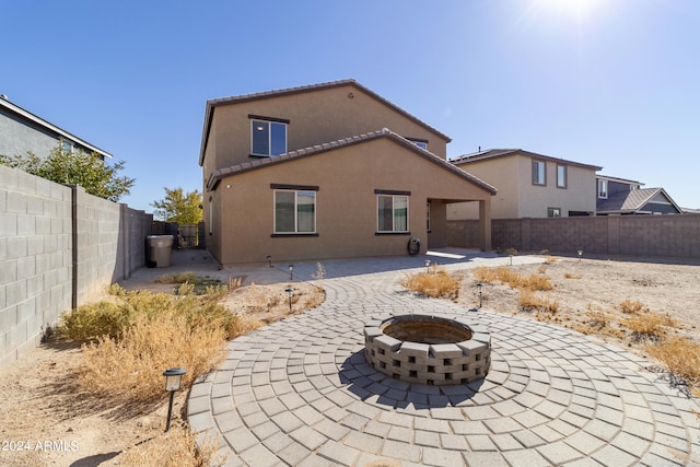 back of property with a patio and a fire pit