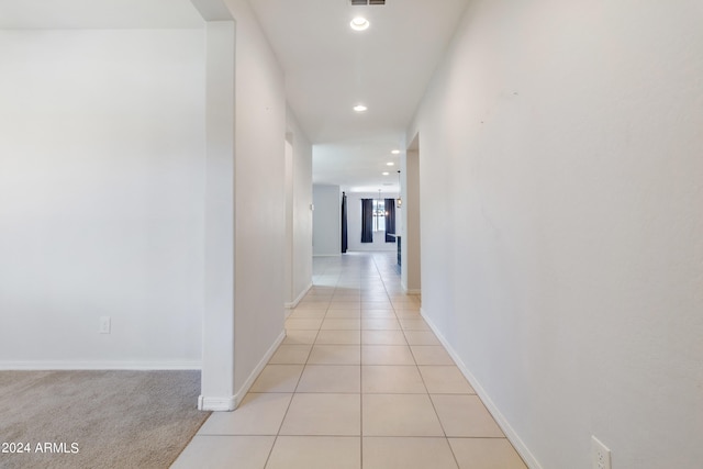 hall with light colored carpet