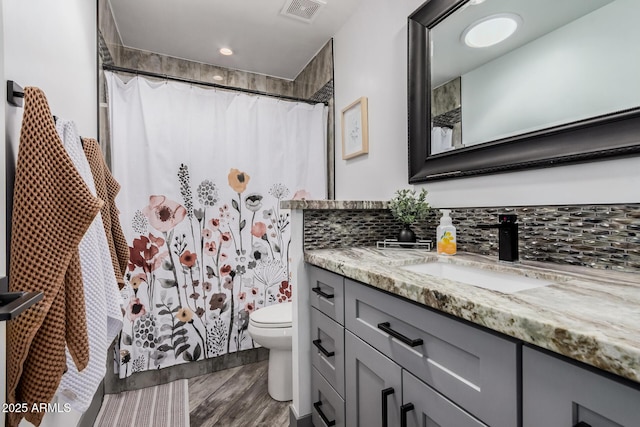 bathroom featuring vanity, a shower with curtain, wood finished floors, visible vents, and toilet