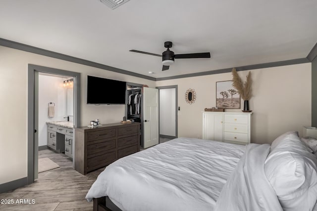 bedroom with visible vents, wood finished floors, connected bathroom, crown molding, and baseboards