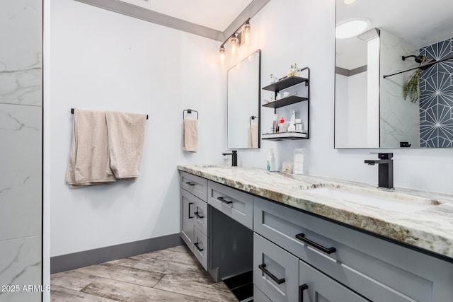 bathroom featuring double vanity, wood tiled floor, baseboards, and a sink