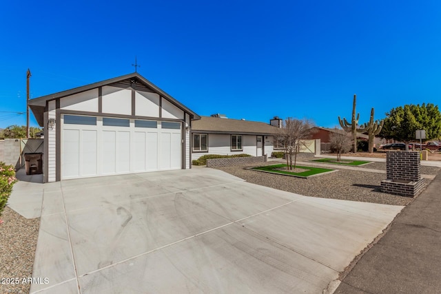 ranch-style home with a garage, driveway, and fence