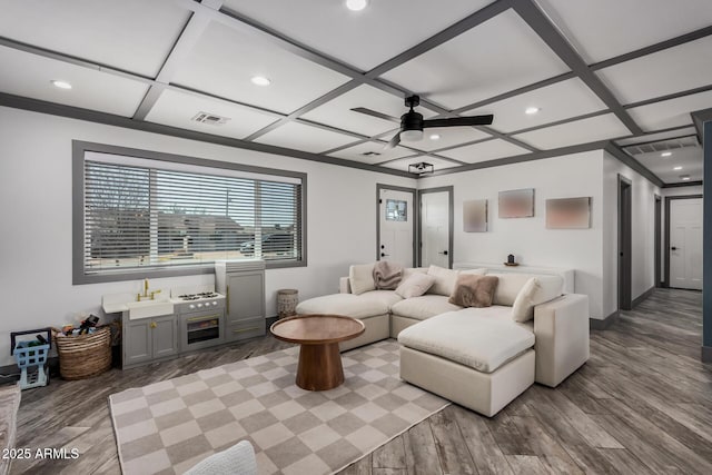 living area with visible vents, coffered ceiling, and wood finished floors