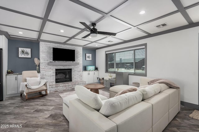 living room with visible vents, a fireplace, dark wood-style floors, coffered ceiling, and a ceiling fan