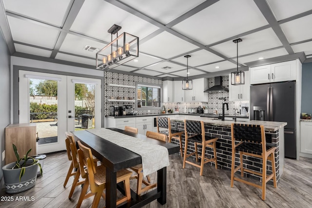 dining area featuring visible vents, coffered ceiling, french doors, and wood finished floors