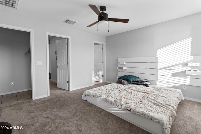 bedroom featuring carpet flooring, ceiling fan, a closet, and a spacious closet