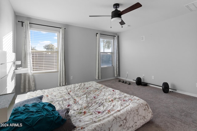 carpeted bedroom featuring ceiling fan and multiple windows