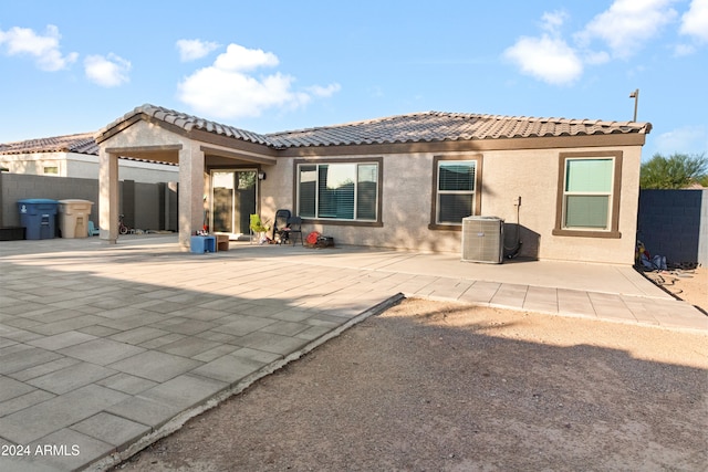 rear view of property with central AC and a patio