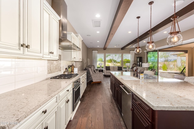 kitchen with stainless steel appliances, beamed ceiling, sink, dark wood-type flooring, and wall chimney range hood