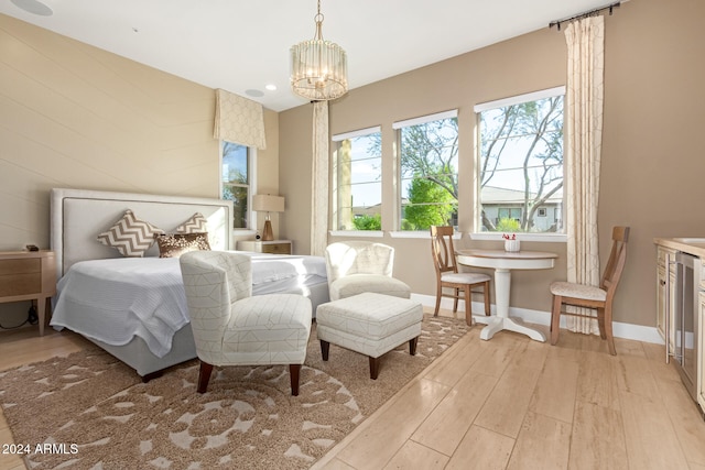 bedroom featuring light wood-type flooring and an inviting chandelier