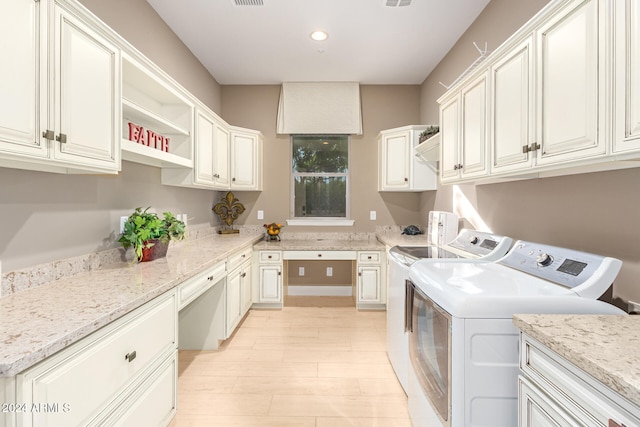 washroom with cabinets and washer and dryer