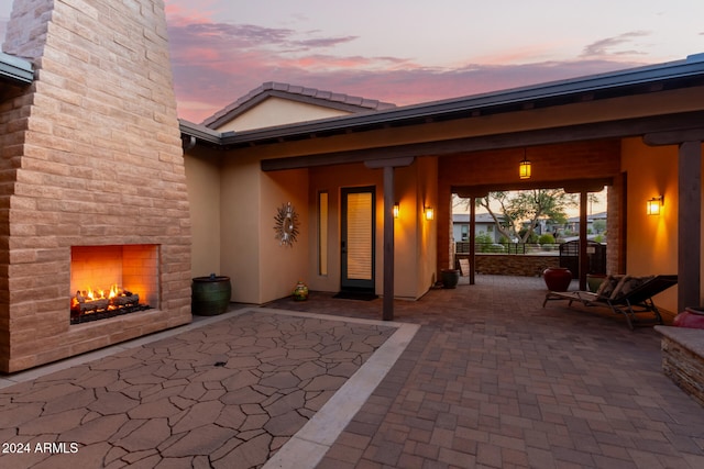 patio terrace at dusk featuring exterior fireplace