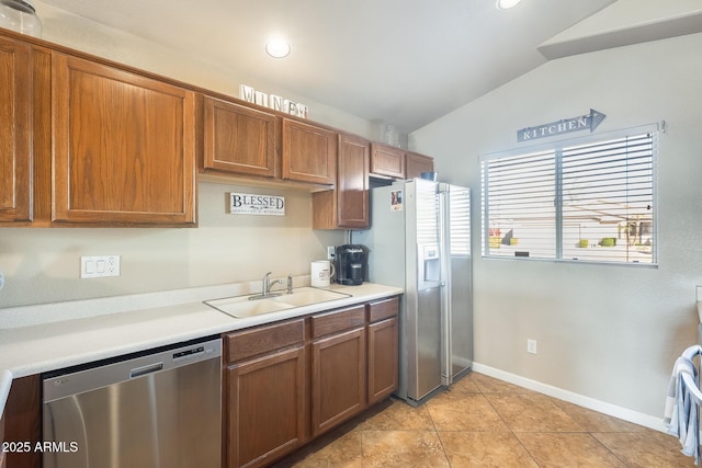 kitchen featuring stainless steel appliances, vaulted ceiling, sink, and light tile patterned floors