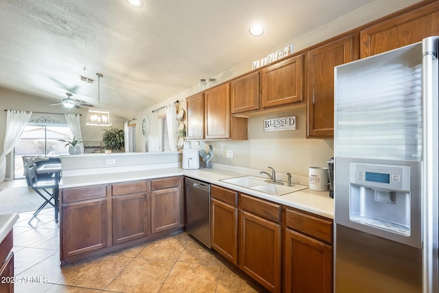 kitchen with stainless steel appliances, sink, pendant lighting, and kitchen peninsula