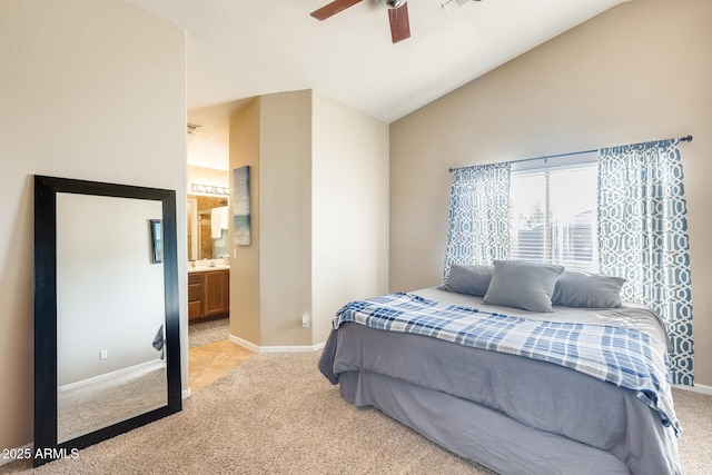 bedroom with ceiling fan, lofted ceiling, ensuite bath, and light carpet