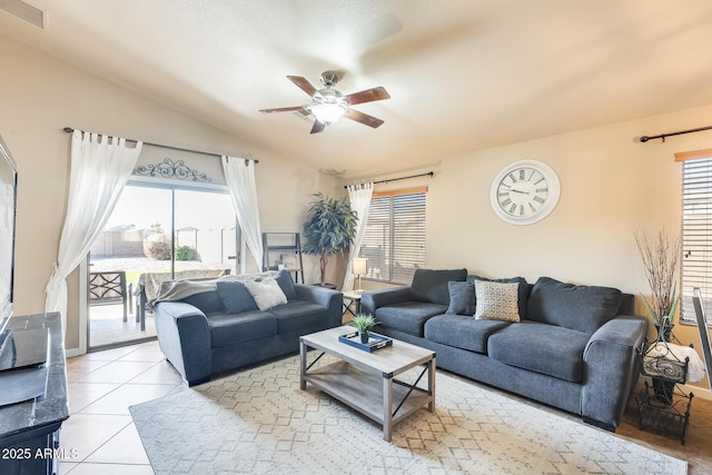 tiled living room featuring ceiling fan and lofted ceiling