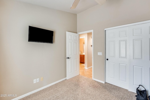 unfurnished bedroom with light colored carpet, a closet, and ceiling fan