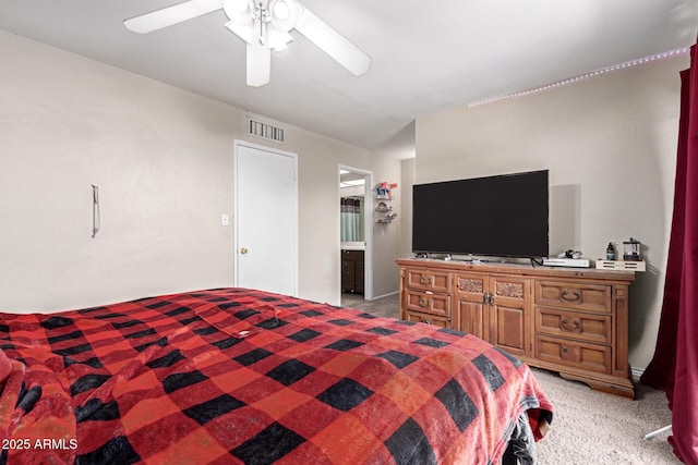 bedroom featuring light colored carpet, ceiling fan, and ensuite bathroom