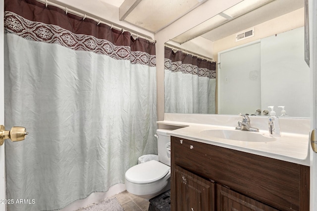 bathroom featuring vanity, tile patterned floors, and toilet