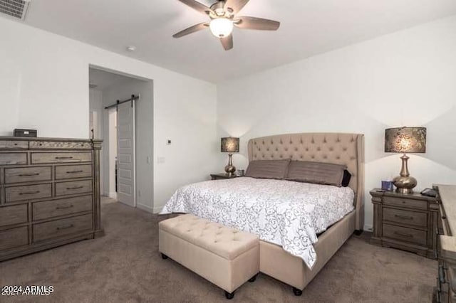 bedroom with a barn door, carpet, and ceiling fan